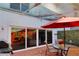 Covered patio with brick flooring, a dining set under a red umbrella, and sliding glass doors for indoor-outdoor living at 2985 W Knights Ave # 2985, Tampa, FL 33611