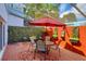 Relaxing covered patio with red brick pavers, dining set, and accent wall at 2985 W Knights Ave # 2985, Tampa, FL 33611
