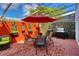 Inviting patio featuring a dining set under an umbrella, a grill, and brick flooring for outdoor relaxation and entertainment at 2985 W Knights Ave # 2985, Tampa, FL 33611