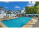 Community pool and surrounding patio area with seating and lush landscaping at 2985 W Knights Ave # 2985, Tampa, FL 33611