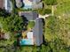 Aerial view of the home, highlighting the swimming pool and roofline surrounded by greenery at 3412 W Mckay Ave, Tampa, FL 33609