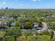 Expansive aerial view of a residential neighborhood, featuring tree-lined streets and manicured lawns, city skyline in background at 3412 W Mckay Ave, Tampa, FL 33609