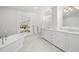 Elegant bathroom featuring a soaking tub, double vanity with marble countertops, and a bright window at 3412 W Mckay Ave, Tampa, FL 33609