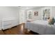 Bright bedroom with hardwood floors, a dresser, and views out of the bright shuttered windows at 3412 W Mckay Ave, Tampa, FL 33609