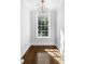 Bright, light-filled empty room with hardwood floors, chandelier, and a large window at 3412 W Mckay Ave, Tampa, FL 33609