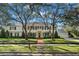 Stately white home framed by mature trees and lush landscaping. Brick walkway leads to the front entrance at 3412 W Mckay Ave, Tampa, FL 33609