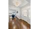 Elegant foyer featuring beautiful hardwood floors, stunning chandelier, and a glimpse into other living spaces at 3412 W Mckay Ave, Tampa, FL 33609