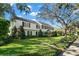 Expansive front yard with lush green grass, manicured landscaping, and a brick walkway to the home at 3412 W Mckay Ave, Tampa, FL 33609