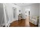 Hallway with hardwood floors, accent chair, and access to bathroom and closet at 3412 W Mckay Ave, Tampa, FL 33609