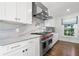 Bright kitchen featuring white cabinets, marble countertops, and stainless steel appliances at 3412 W Mckay Ave, Tampa, FL 33609