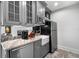 This wet bar and kitchenette features gray cabinets, stainless steel appliances and granite counters at 3412 W Mckay Ave, Tampa, FL 33609