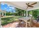 Covered outdoor dining area with a ceiling fan, brick patio, and views of the backyard at 3412 W Mckay Ave, Tampa, FL 33609