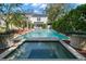 Backyard pool and spa with lush landscaping, a brick patio, and an outdoor living space at 3412 W Mckay Ave, Tampa, FL 33609