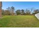 Large backyard surrounded by mature trees and a white fence, providing a serene and private outdoor space at 3613 Pendleton Way, Land O Lakes, FL 34639