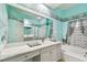 Bright bathroom with a tub, shower, white cabinets, and a large mirror over the vanity at 3613 Pendleton Way, Land O Lakes, FL 34639