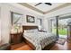 Bright bedroom with a tray ceiling, hardwood floors and a sliding glass door to the outdoors at 3613 Pendleton Way, Land O Lakes, FL 34639