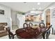 A dining room featuring a dark wood table with the kitchen and staircase in the background at 3613 Pendleton Way, Land O Lakes, FL 34639
