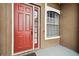 A close up of a brown single Gathering home's entry way featuring a red door at 3613 Pendleton Way, Land O Lakes, FL 34639