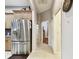 Hallway featuring wood cabinets, a stainless steel refrigerator, and tile floors at 3613 Pendleton Way, Land O Lakes, FL 34639