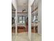 Hallway with mirrored closet doors leading to the main bedroom with backyard access at 3613 Pendleton Way, Land O Lakes, FL 34639