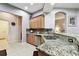 Open kitchen featuring granite counters, tile backsplash, light wood cabinetry, and bar stool seating at 3613 Pendleton Way, Land O Lakes, FL 34639
