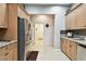 A kitchen featuring tile floors, granite countertops, stainless steel appliances, and natural wood cabinetry at 3613 Pendleton Way, Land O Lakes, FL 34639