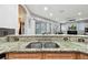 Bright kitchen featuring granite countertops, stainless steel sink, wood cabinets, and an open design to the rest of the house at 3613 Pendleton Way, Land O Lakes, FL 34639