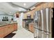 Kitchen featuring stainless steel appliances, wooden cabinets, and open view to the staircase and Gathering room at 3613 Pendleton Way, Land O Lakes, FL 34639