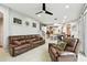 Living room featuring tile floors, leather sofas and recliners, and a view into the kitchen at 3613 Pendleton Way, Land O Lakes, FL 34639