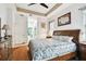 Comfortable main bedroom boasting a tray ceiling and an ensuite bathroom for added convenience at 3613 Pendleton Way, Land O Lakes, FL 34639
