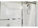 Close-up of a shower with a textured glass door and a shower curtain at 3613 Pendleton Way, Land O Lakes, FL 34639