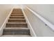 Carpeted stairs with a white handrail leading to the upper level of the house at 3613 Pendleton Way, Land O Lakes, FL 34639