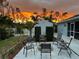 Charming backyard with a fire pit, chairs, manicured hedges and sunset at 3655 Candia Ave, North Port, FL 34286
