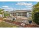 A screened in back porch and landscaped yard with mature trees and shrubs at 3655 Candia Ave, North Port, FL 34286