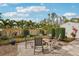 Landscaped backyard area with seating surrounding a fire pit with pavers at 3655 Candia Ave, North Port, FL 34286