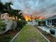 Inviting backyard with a lush lawn, paved patio, outdoor seating, and a shed with a vibrant sunset view at 3655 Candia Ave, North Port, FL 34286
