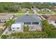 Aerial shot showcasing a screened patio, outdoor firepit, shed, and lush palm trees at 3655 Candia Ave, North Port, FL 34286