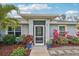 Inviting front entrance with a screened porch, colorful landscaping, and stone pathway at 3655 Candia Ave, North Port, FL 34286