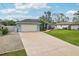 View of the home's driveway, two-car garage, and low maintenance landscaping at 3655 Candia Ave, North Port, FL 34286