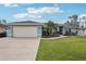 Charming single-story home with a well-manicured lawn, mature landscaping, and an attached two-car garage at 3655 Candia Ave, North Port, FL 34286