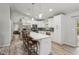 Modern, all-white kitchen with stainless steel appliances, quartz countertops, and pendant lighting at 3655 Candia Ave, North Port, FL 34286