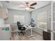 Bright home office features a ceiling fan, modern desk with dual monitors, and wood-look flooring at 3655 Candia Ave, North Port, FL 34286