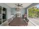 Outdoor kitchen area with stainless steel grill, ceiling fan, dining, and lush greenery at 3655 Candia Ave, North Port, FL 34286