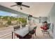 Spacious screened patio features a ceiling fan, mounted TV, and outdoor dining area with lush landscaping views at 3655 Candia Ave, North Port, FL 34286