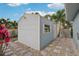Outdoor shed features durable siding, a window, and door, surrounded by a pea gravel bed and stepping stone path at 3655 Candia Ave, North Port, FL 34286
