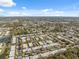 Expansive aerial view of a residential community with lush greenery, a nearby lake, and clear blue skies at 4222 Richmere Dr # 4222, New Port Richey, FL 34652
