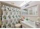 The bathroom showcases a shower-tub combo with floral curtain, white fixtures, and a decorative mirror at 4222 Richmere Dr # 4222, New Port Richey, FL 34652