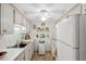 Functional white kitchen with ample cabinet space, white appliances, and a ceiling fan at 4222 Richmere Dr # 4222, New Port Richey, FL 34652