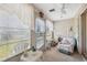 Bright sunroom with multiple windows, blinds, lace curtains, and cozy furniture at 4222 Richmere Dr # 4222, New Port Richey, FL 34652