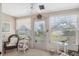Bright sunroom with multiple windows, blinds, lace curtains, and cozy wicker furniture at 4222 Richmere Dr # 4222, New Port Richey, FL 34652